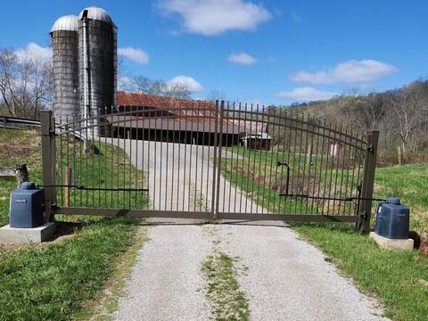 Fence with Metal double swing gate with a gate operator installed for a farm property in West Virginia in West Virginia